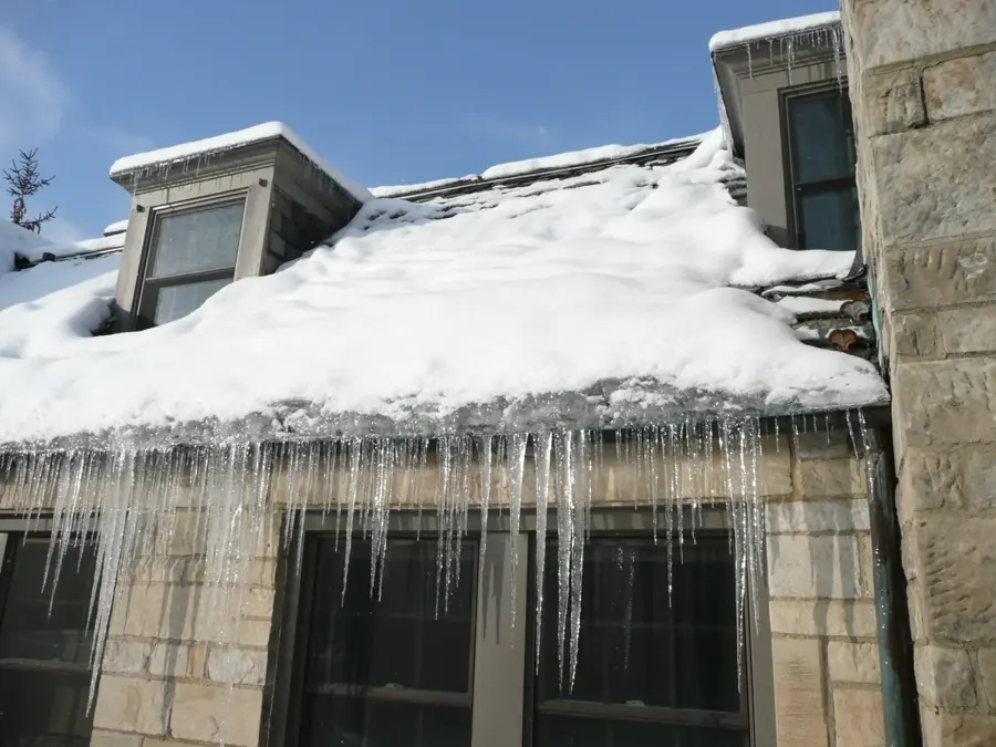 Ice dam and icicles on a snow-loaded Big Lake, MN roof edge